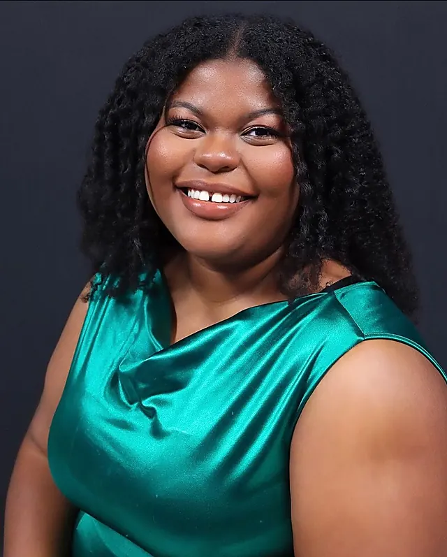 Leyna Paul, the photographer, in a teal satin dress