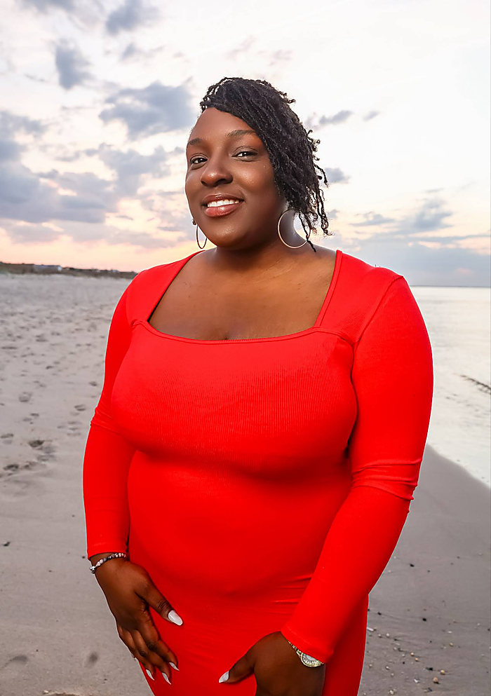 A beach portrait at sunset, close in: a red square-neck dress, the water behind