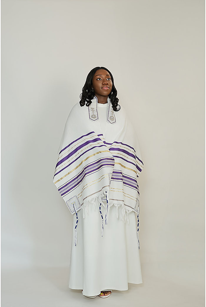 A full-length portrait on gray: a white gown under a white shawl with purple stripes